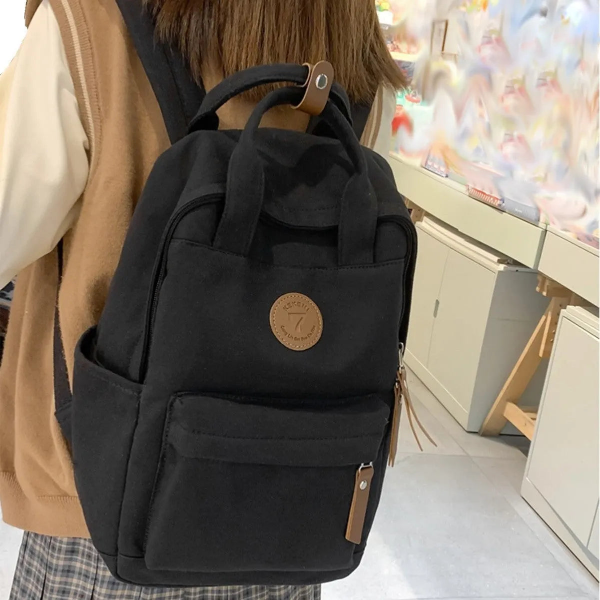 Black Oxford cloth backpack with curved shoulder straps and retro sewing thread detailing