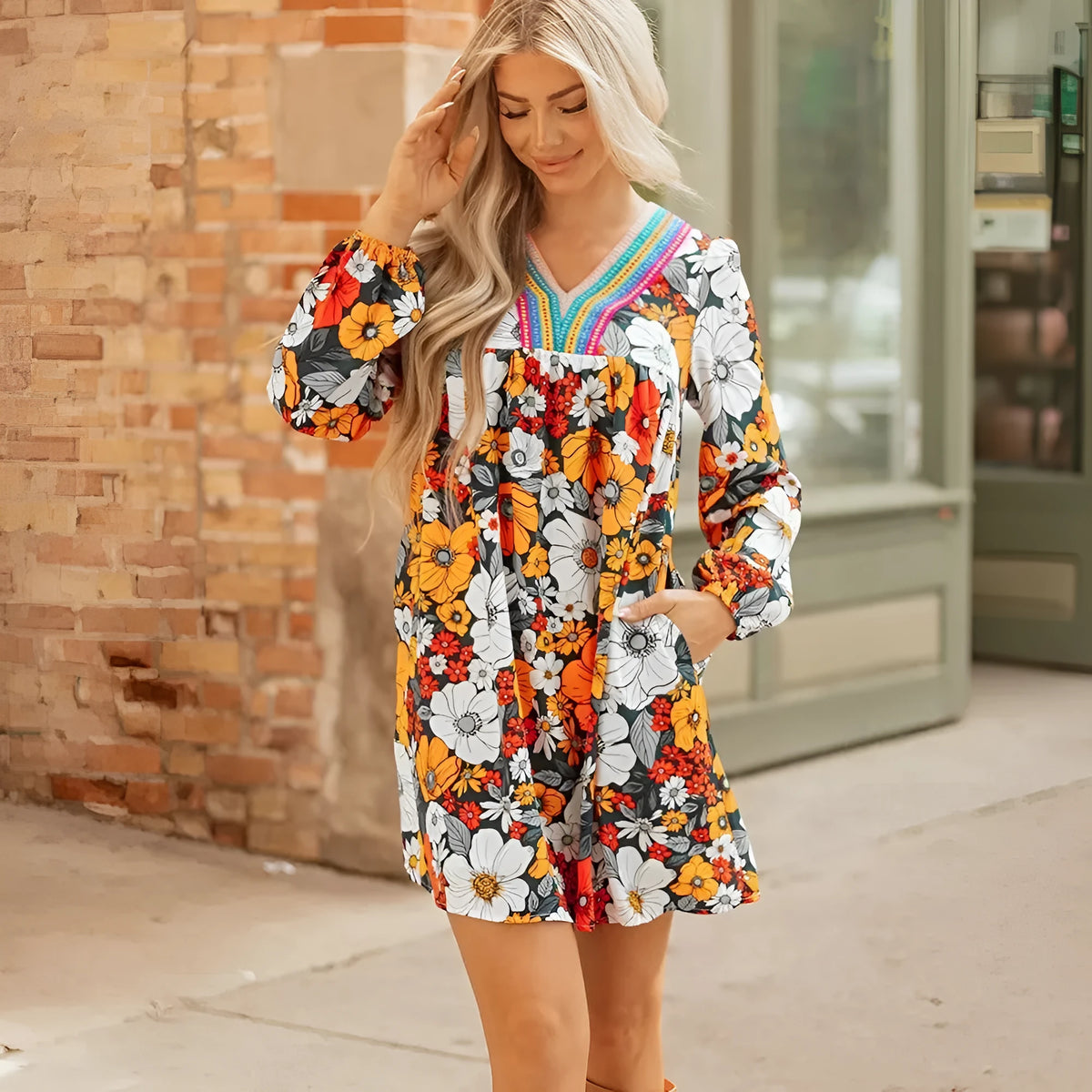 Orange floral print mini dress with lace trim, V-neckline, and long sleeves