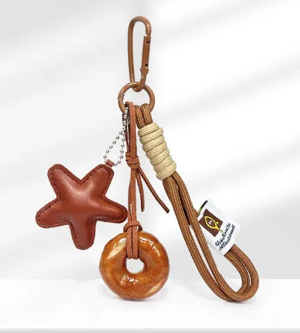 Handmade soda bread style handbag pendant with brown strap showing cartoon baked goods design