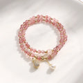 Close-up of a women's geometric bracelet made from pink strawberry quartz crystals.