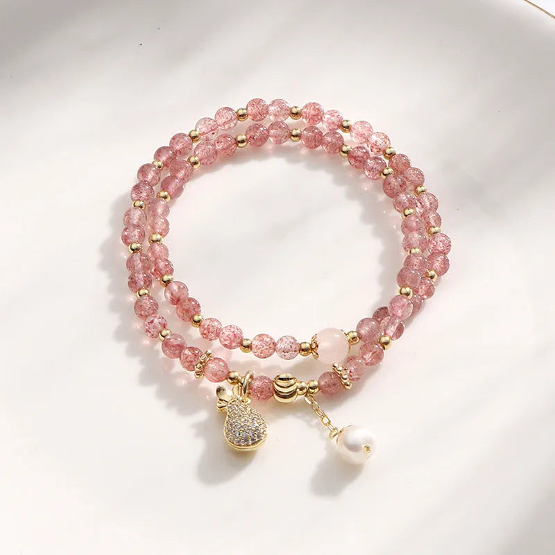 Close-up of a women's geometric bracelet made from pink strawberry quartz crystals.