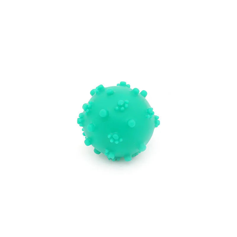 Set of four brightly coloured spiked squeaky dog balls on a blue background