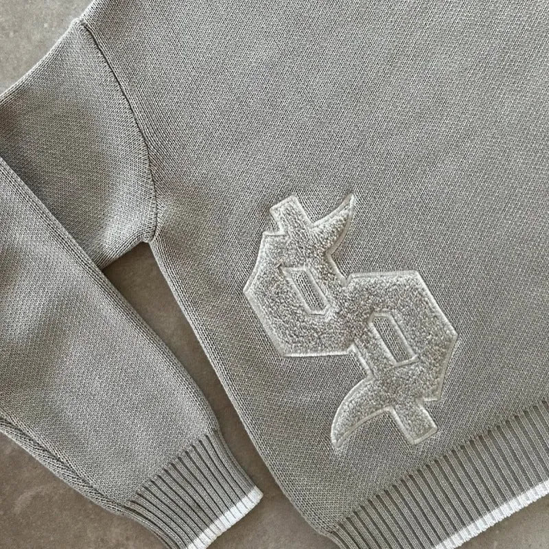 Grey loose-fitting jacquard knitwear coat with long sleeves on a hanger