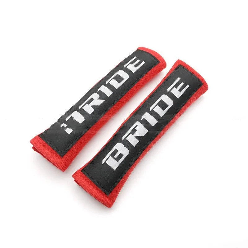 Pair of black car seat belt shoulder pads made from cotton sponge cloth, showing embroidery detail.