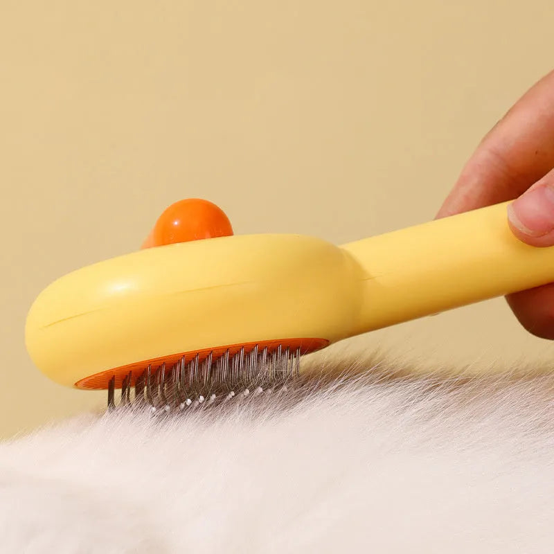 Small yellow duck-shaped pet comb with detachable needle teeth for cat and dog grooming.