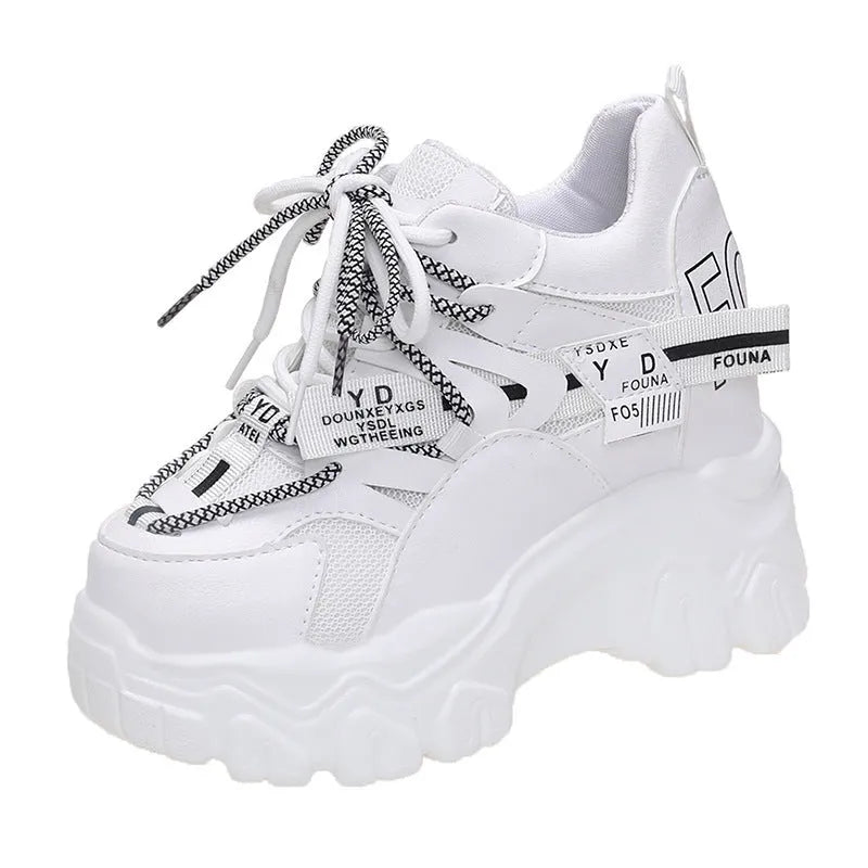 Women's white low-top platform trainers with mesh panels and a black cross-strap over the vamp.