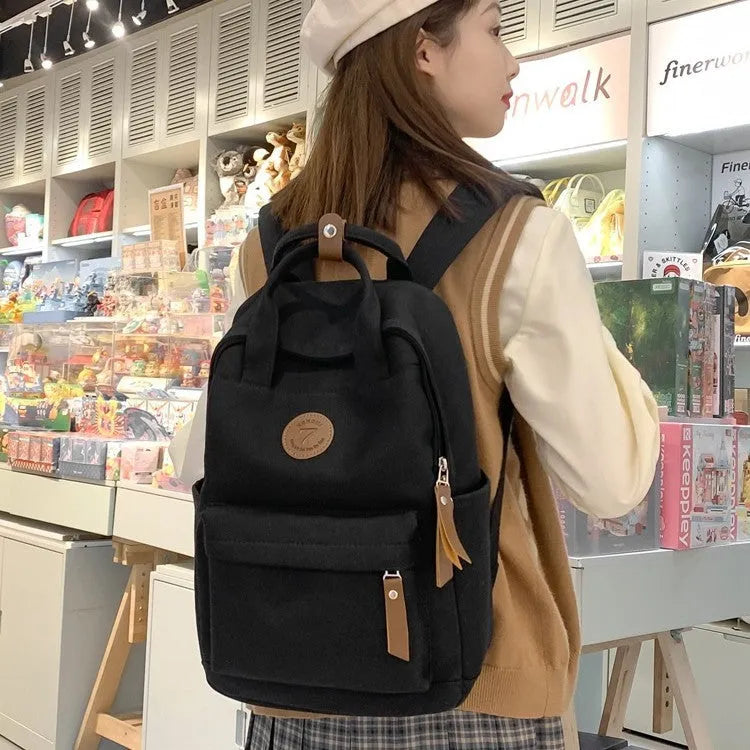 Black Oxford cloth backpack with curved shoulder straps and retro sewing thread detailing