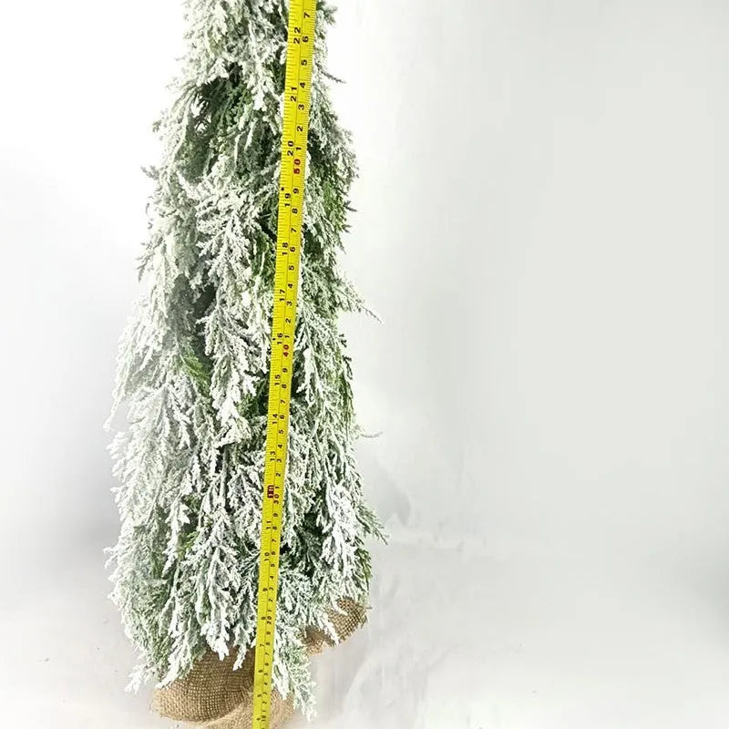 24-inch artificial Christmas tree with snow spray finish and integrated lights on desktop