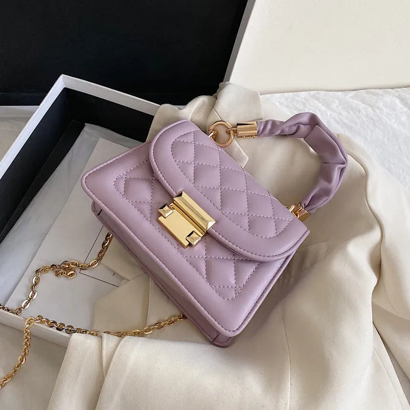 Small purple rhombus-shaped square shoulder bag with a long crossbody strap