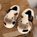 White cartoon cow plush slippers for women with a non-slip textured sole.