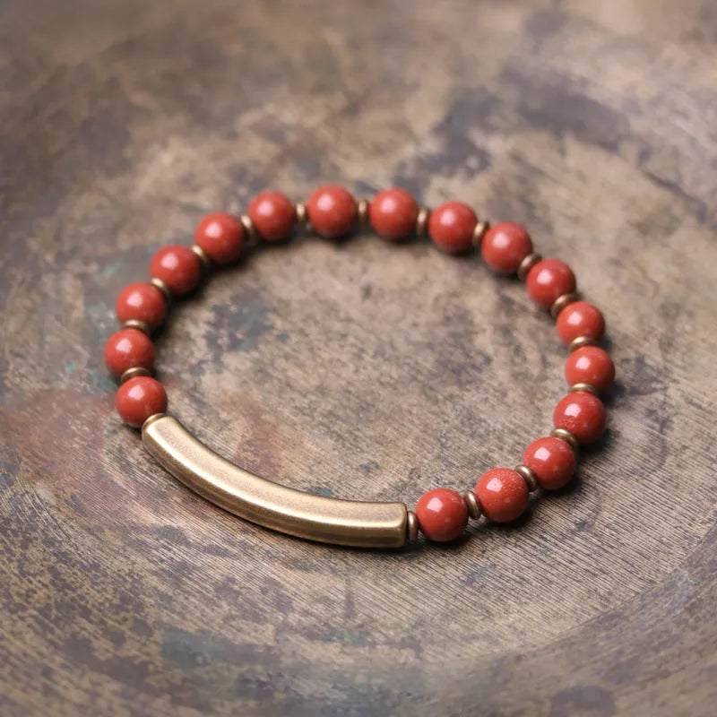 Layered unisex bracelet with water plants agate, red jasper, and obsidian stones on a wrist.