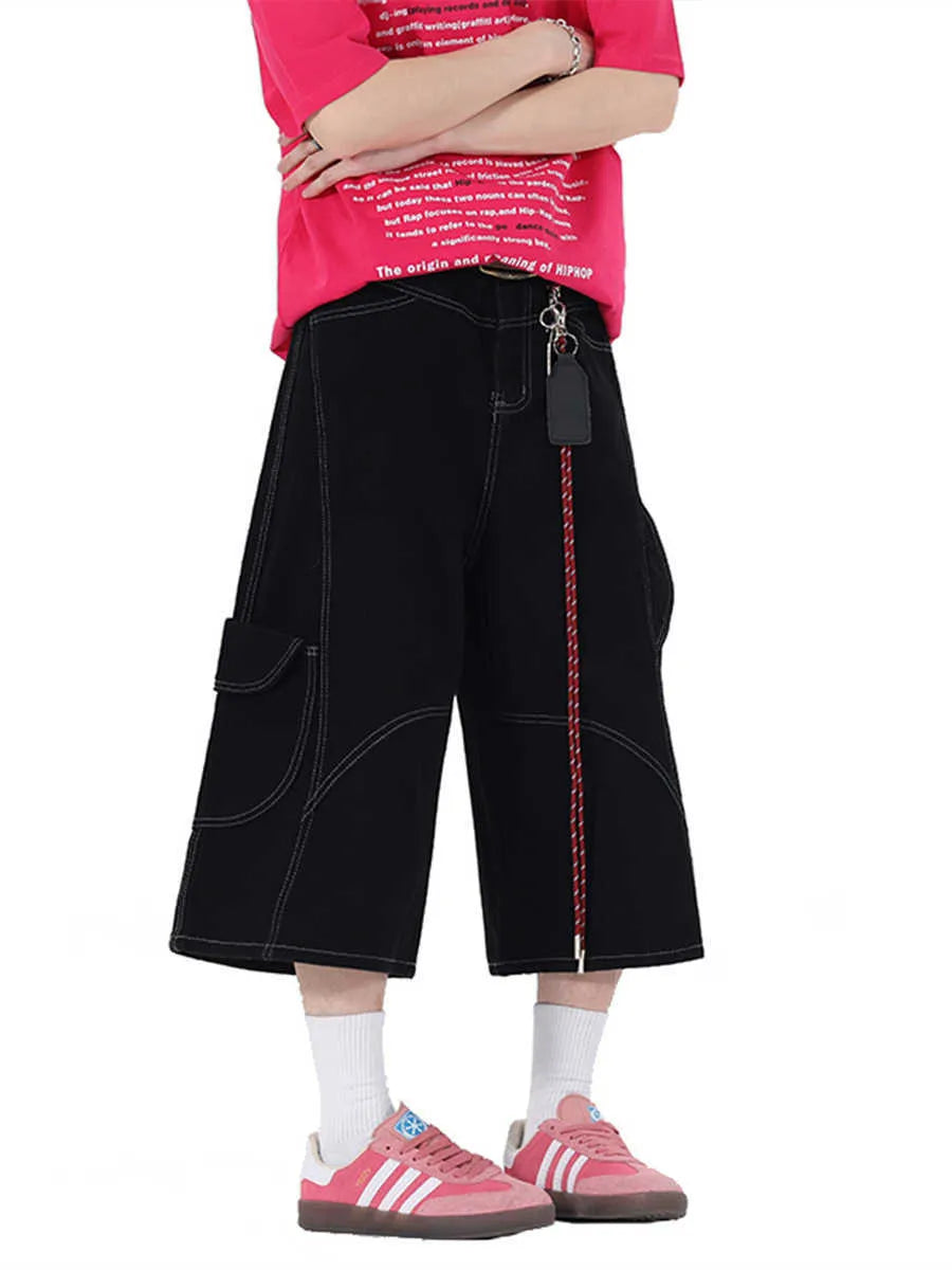 Red denim retro workwear shorts with multiple pockets and a wide-leg cropped fit on a model.