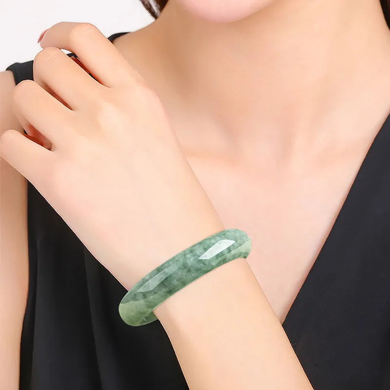 A simple deep pea green ring bracelet for women on a white background, showing its adjustable size.