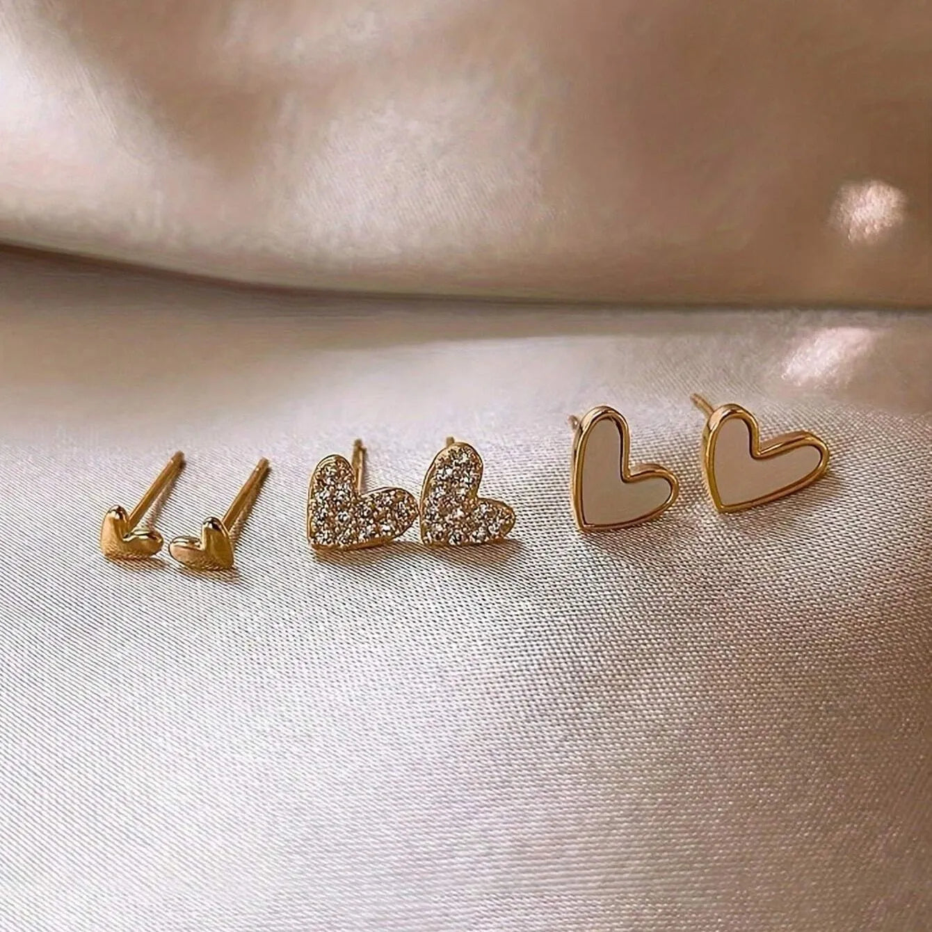 Women's three-pair heart-shaped love earrings set in gold, black, and pink colours with sweet girly style