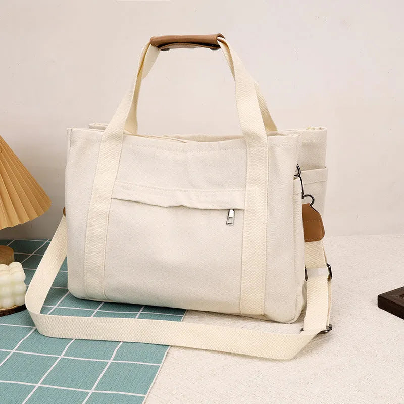Women's large capacity canvas tote bag with multiple internal pockets in horizontal square design