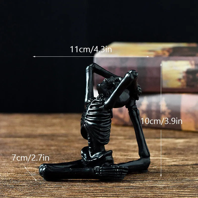 Detailed resin Halloween ornament of a yoga-posing skeleton skull on a desktop.