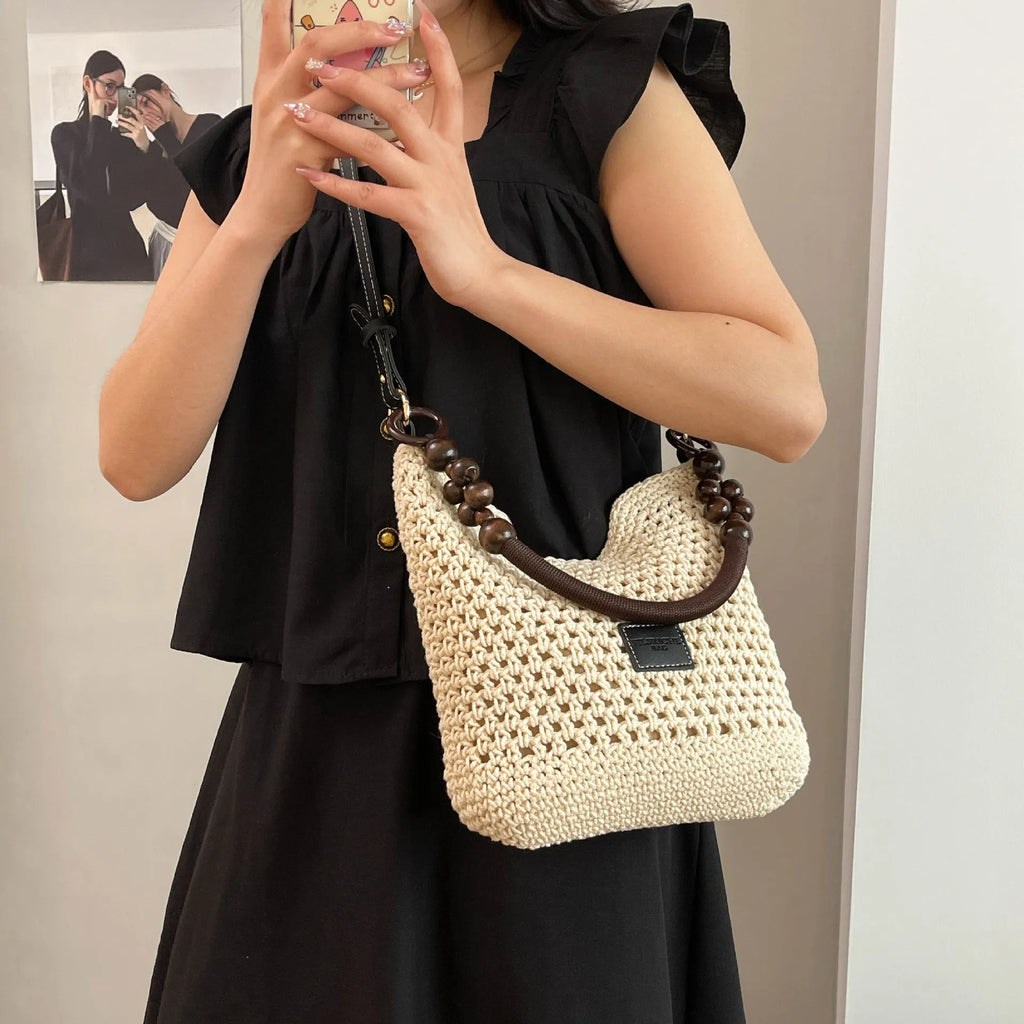 Knitted beach tote bag with crossbody strap showing stitching details and bucket shape