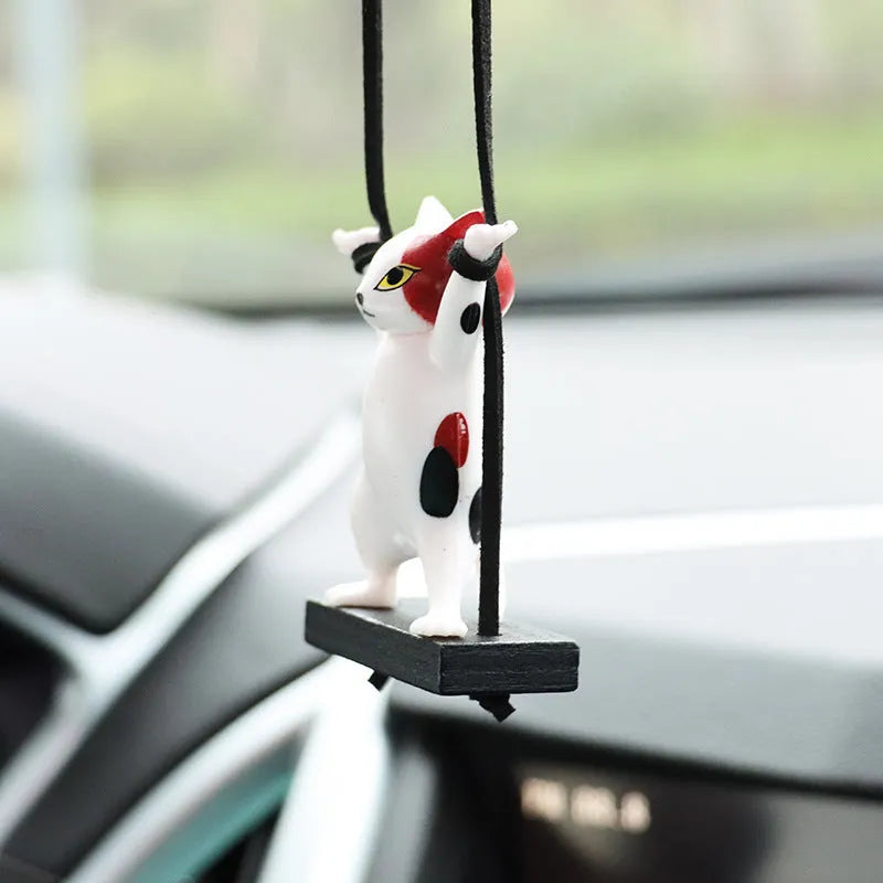 Cartoon-style resin cat pendant car ornament with adjustable rope in colour options including black, white, floral, grey, and brown.