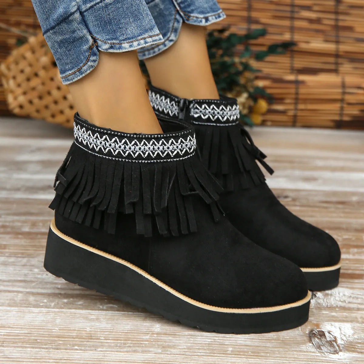 Women's black suede wedge ankle boot with side zip, tassel, and thick rubber sole.