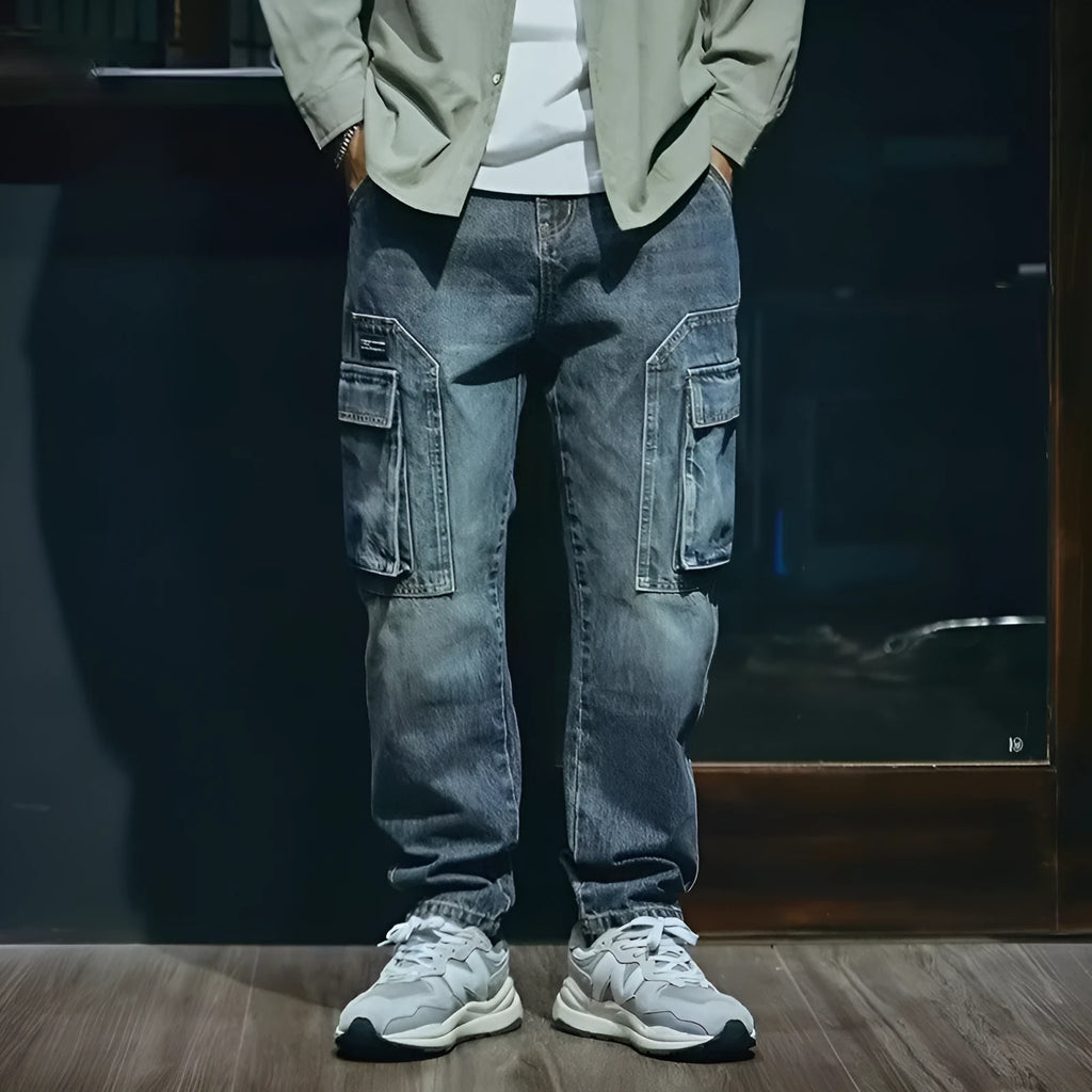 Man wearing blue loose straight-leg retro style stretch denim pants.