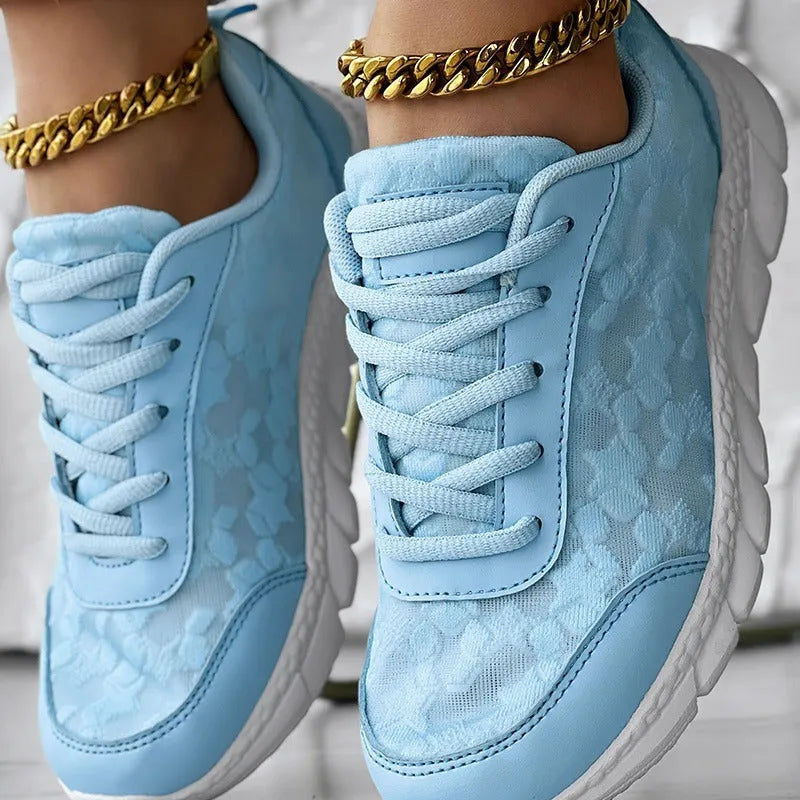 Women's white canvas casual sports shoes with soft bottom and flat heel on a light background.