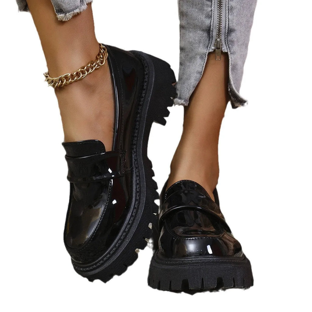 Women's plus size black slip-on loafers with a chunky platform heel and rubber sole.