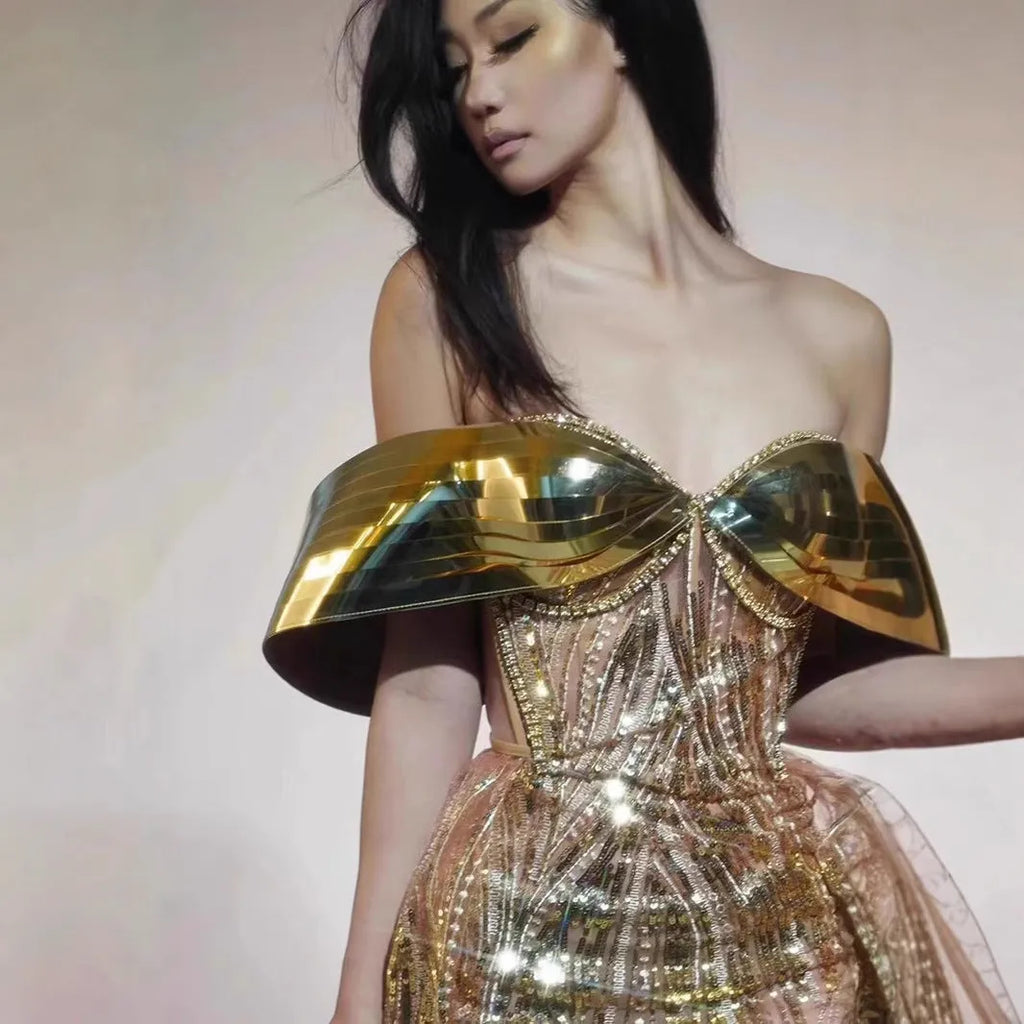 Gold strapless sequin evening dress with a voluminous tulle skirt and a high thigh split.