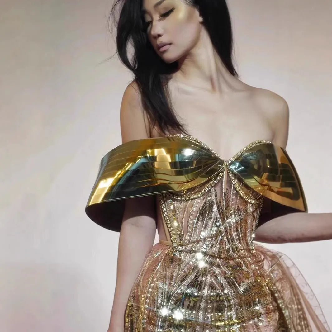 Gold strapless sequin evening dress with a voluminous tulle skirt and a high thigh split.