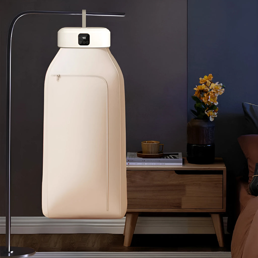 White cylindrical foldable clothes dryer with remote control on flat surface showing compact dimensions