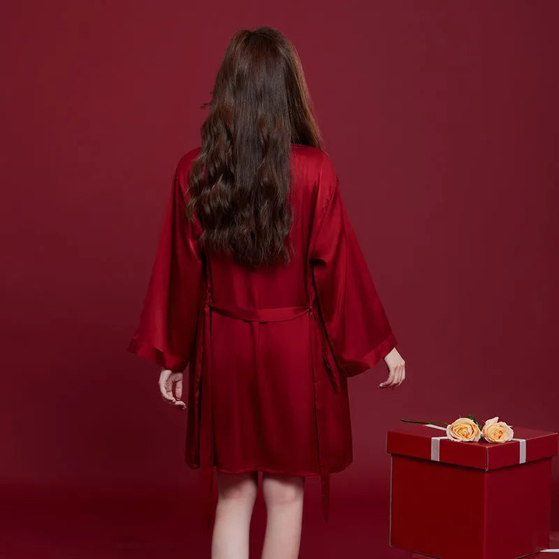 Red matching men's and women's silk sleepwear set with long sleeves and trousers.