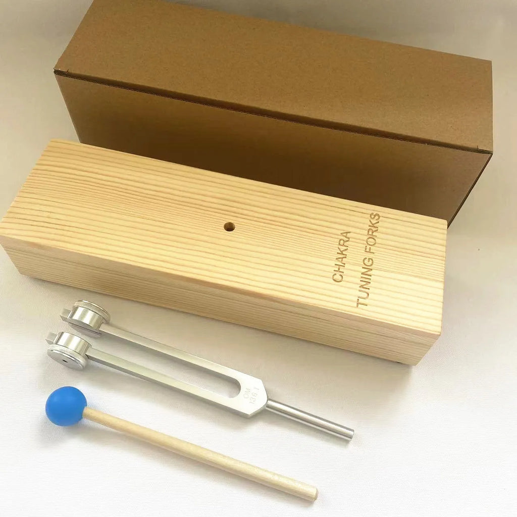 Aluminium alloy 432 Hz tuning fork with a matching speaker unit on a kraft paper box.