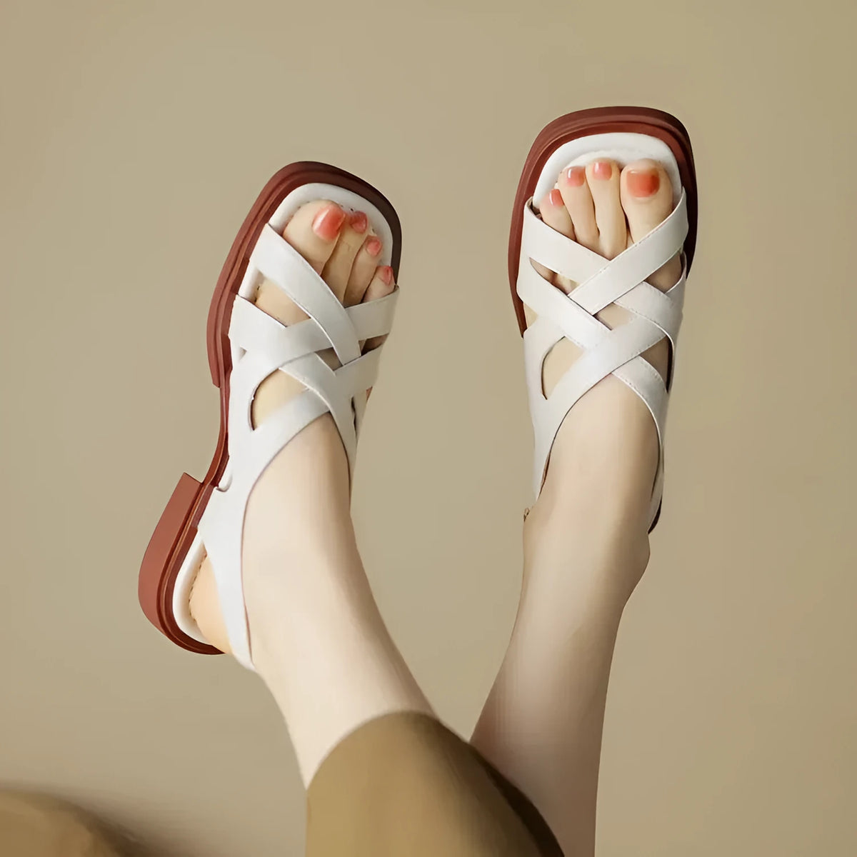 Women's black patent leather square toe beach sandals with cross-band strap on a low rubber sole.