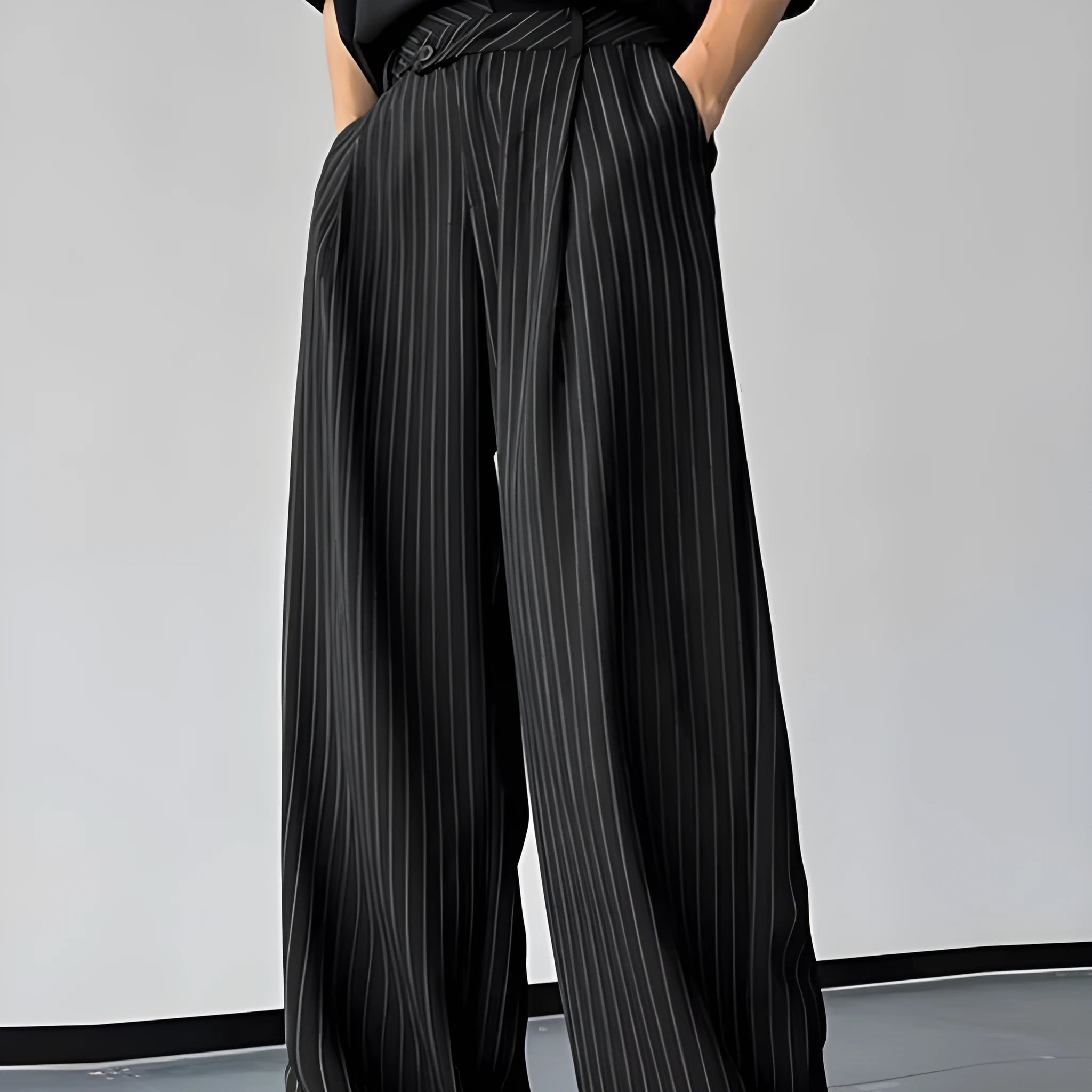 Men's black vertical striped pleated casual trousers showing elastic waistband and leg detail