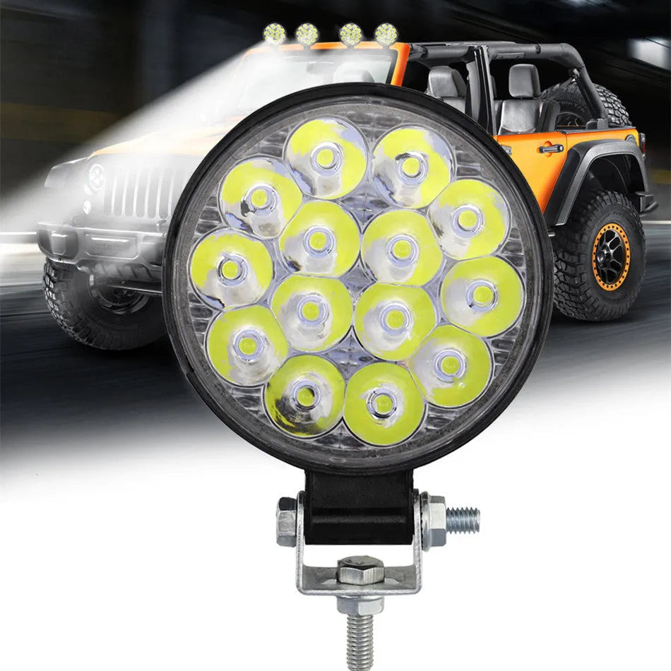 Compact round 42W LED work light with aluminium housing for car, truck, or motorcycle.