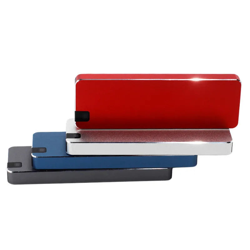 Compact silver portable solid state hard drive with USB cable on a dark surface