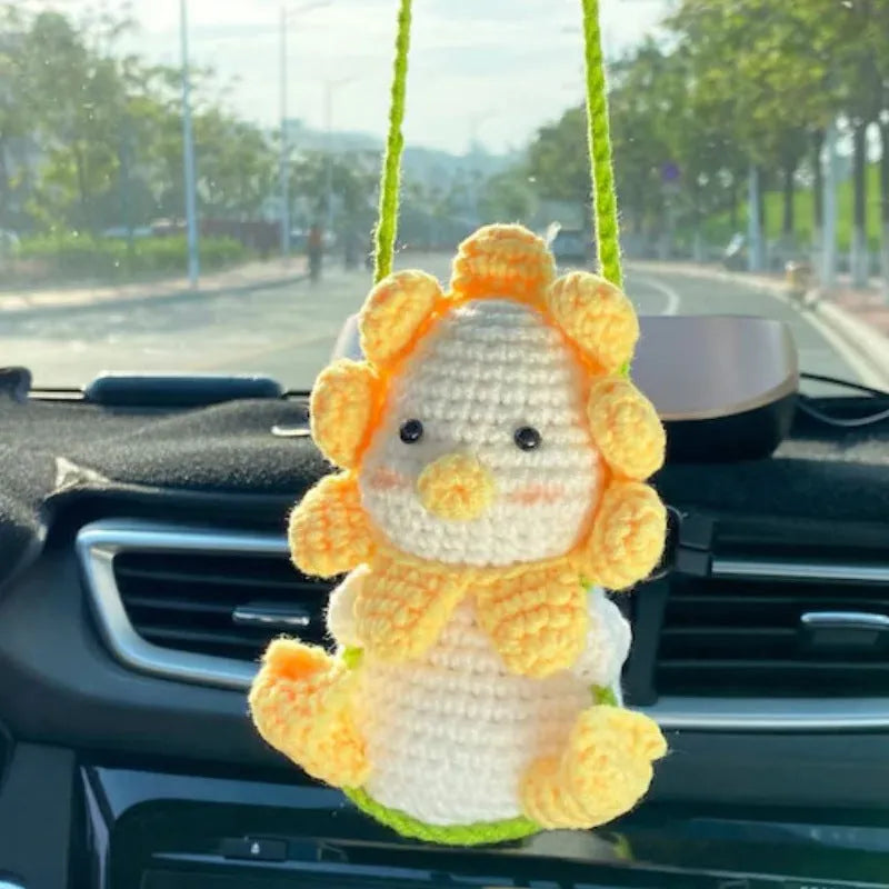 Green and white knitted wool car plant decoration basket with white hanging cord.
