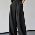 Men's black vertical striped pleated casual trousers showing elastic waistband and leg detail