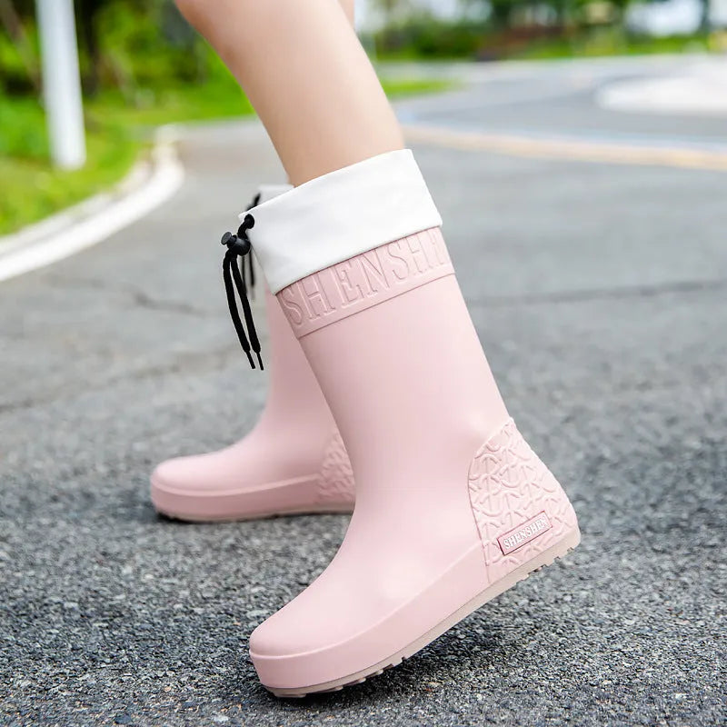 Women's solid colour PVC rain boots in apricot, black, brown, or pink.