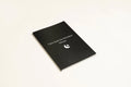 Black hardcover A5 dot grid Dream Journal notebook open on a dot grid cream paper page.
