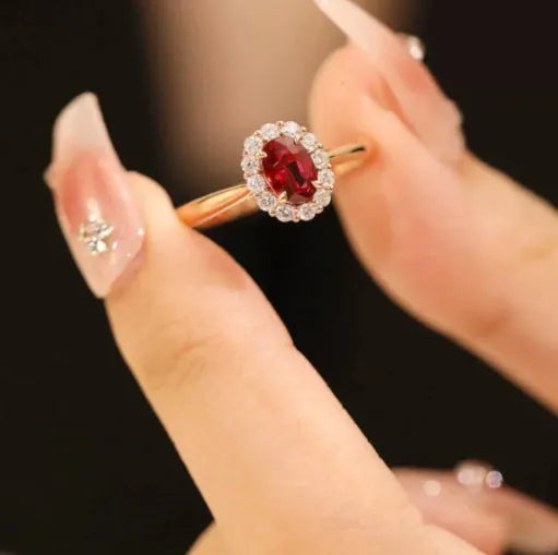 Women's silver ring with gold pigeon design and large red gemstone inlay on a floral pattern band.