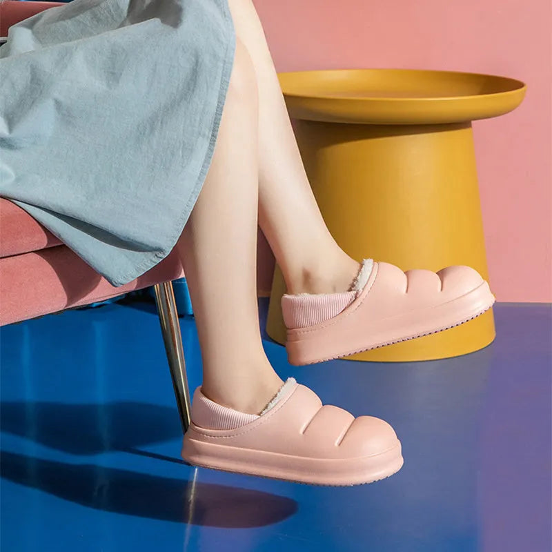 A pair of waterproof EVA couple slippers with a plush lining, shown in a choice of colours like green, pink, or grey.