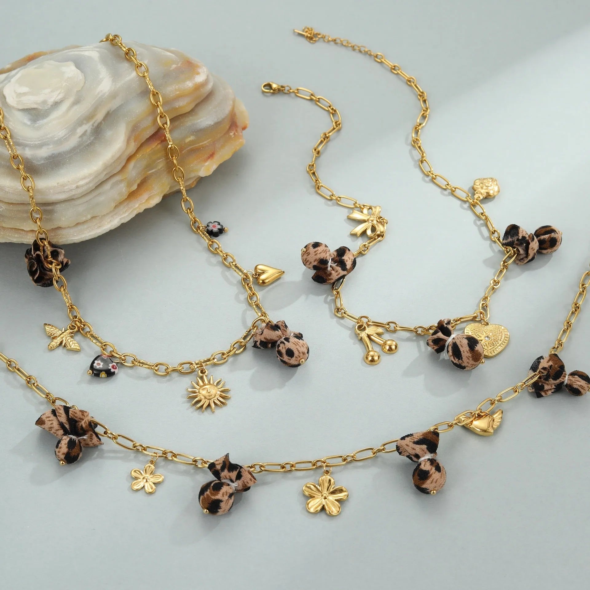 Stainless steel necklace with gold electroplated leopard pendant featuring love heart flowers on geometric design