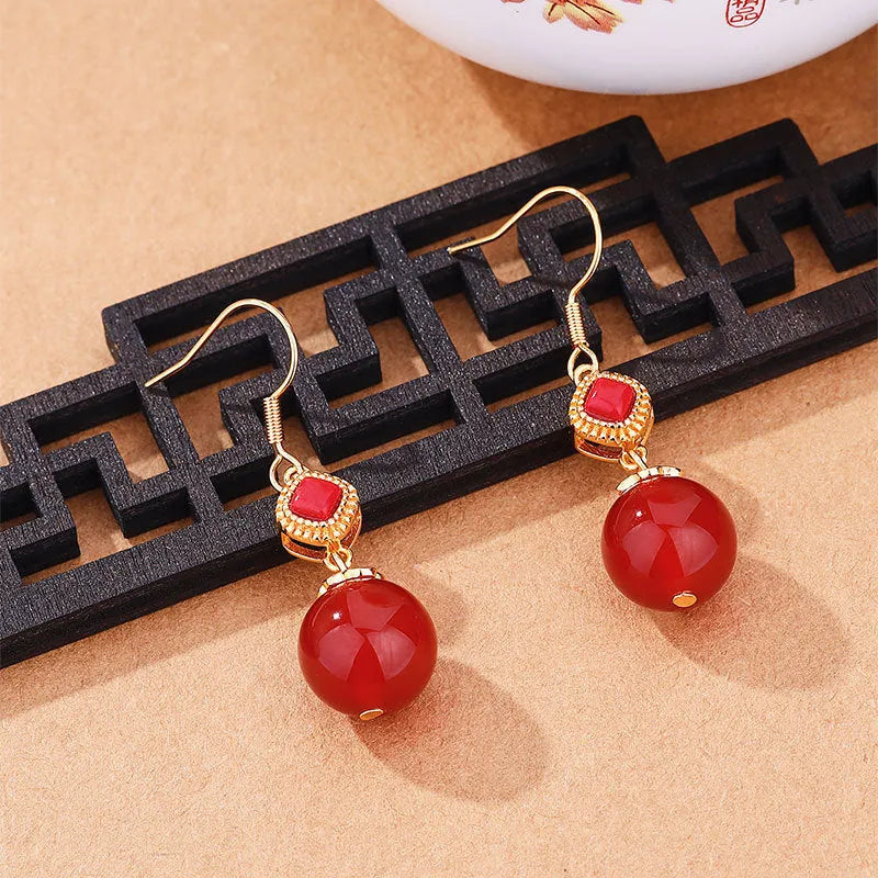 Geometric copper earrings with round red agate beads and silver jasper inlay.