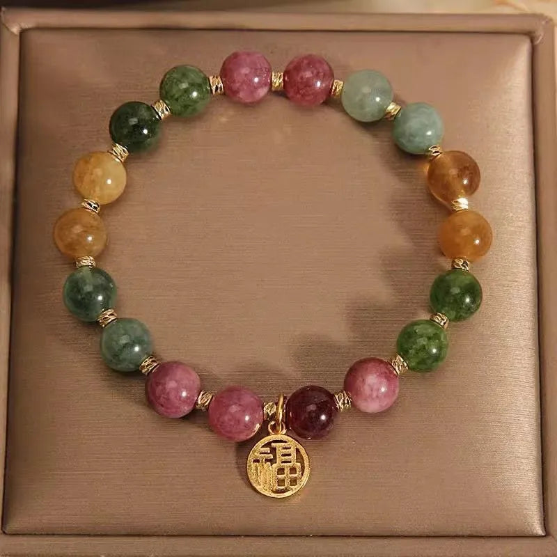 Natural tourmaline bracelet with flower and Fu charms on silver-tone electroplated brass.