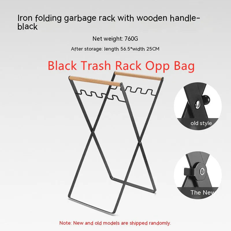 Black foldable outdoor iron trash rack with wooden handle holding a white bin bag.