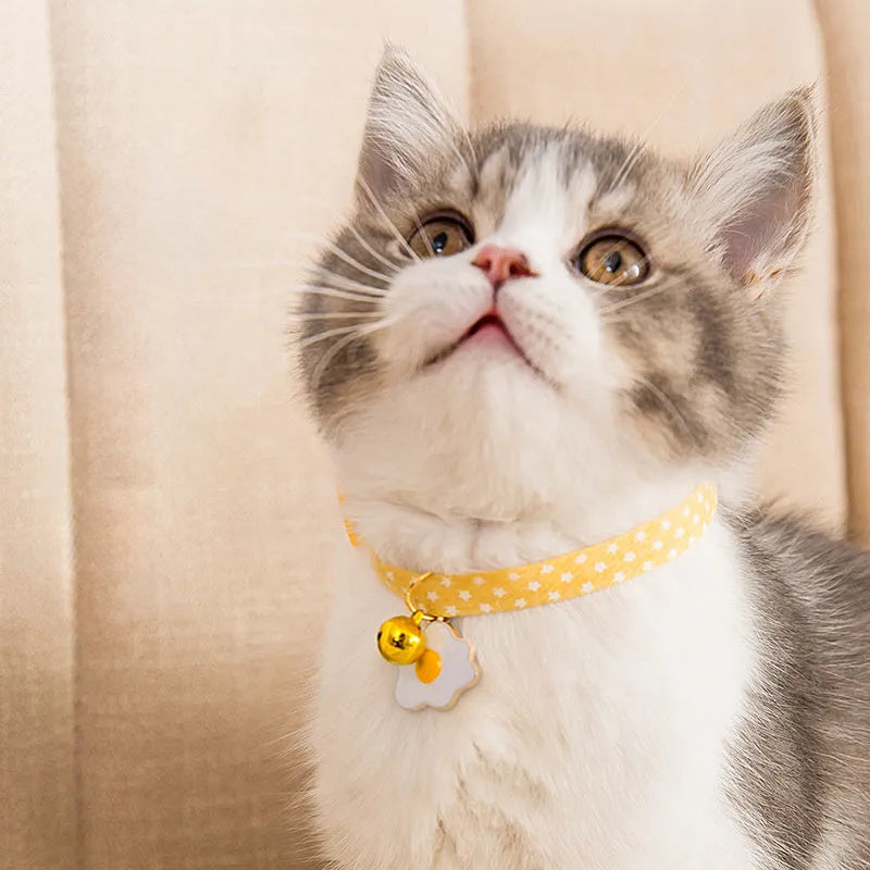 Green adjustable pet collar with a pink bow tie and silver bell for a small dog or cat