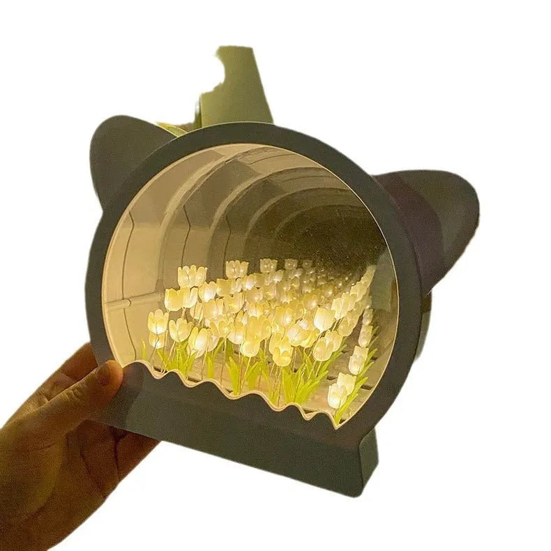 DIY craft kit for a cat head night lamp surrounded by handmade pink, blue, and purple tulip flowers.