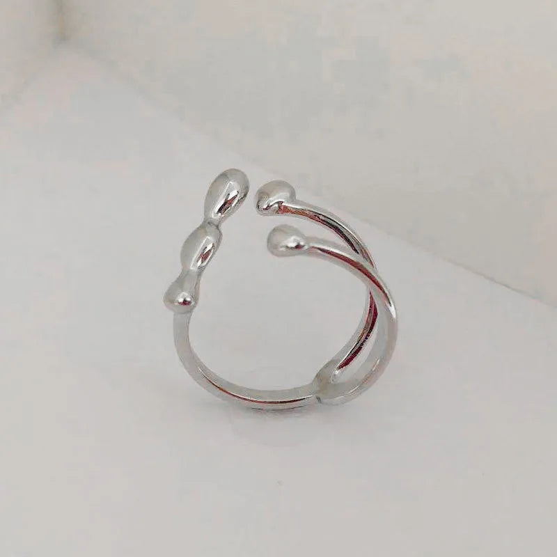 Brass opening ring with spherical elements in gold or silver finish