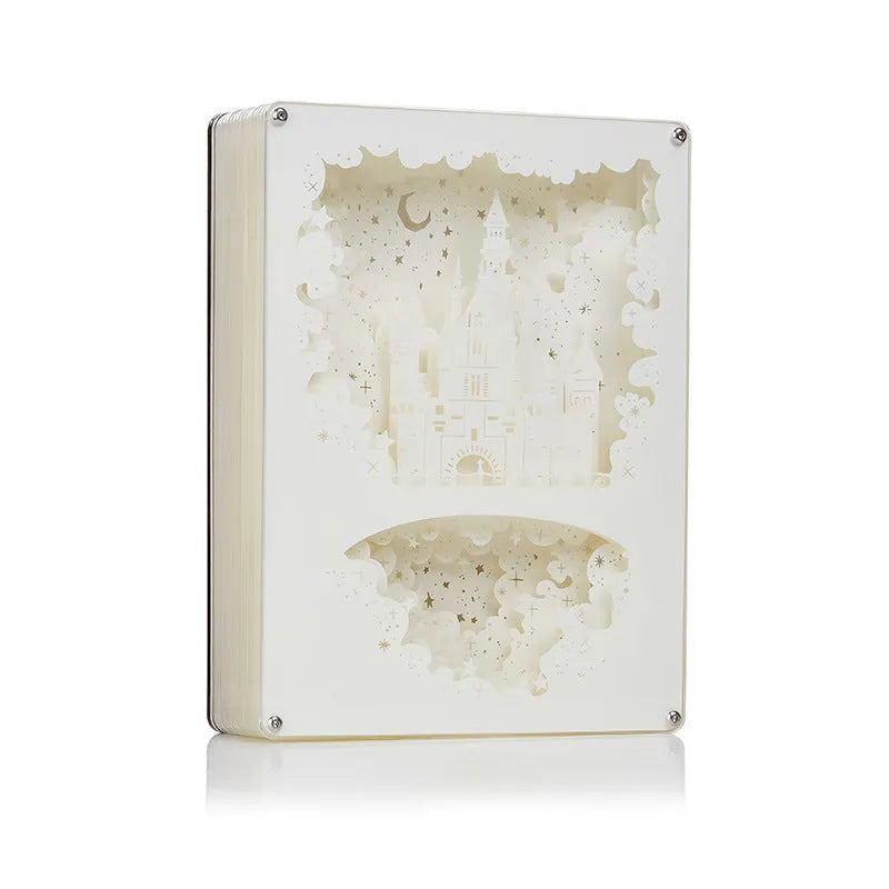 Modern bedside night light with 3D paper carving design on white plastic shade, showing yellow ambient glow.