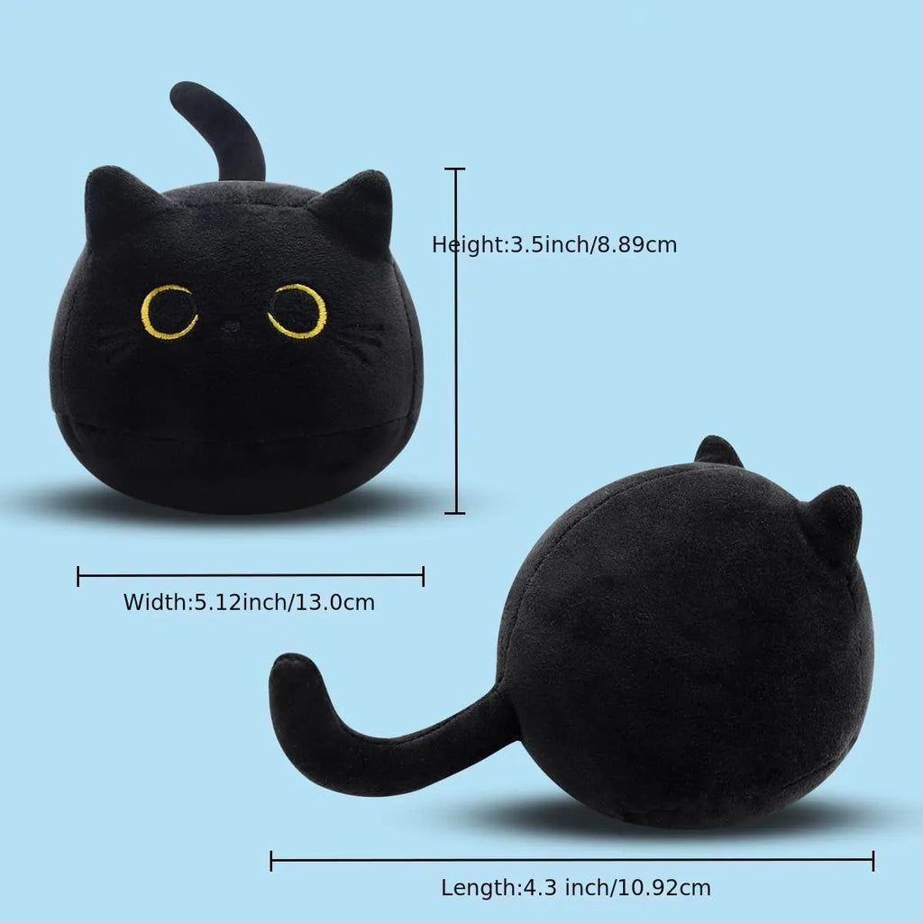 Black fluffy cat plush toy stuffed animal on a sofa, used as a soft cushion.